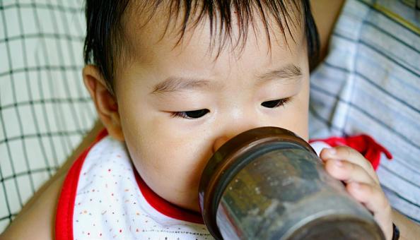 マグで麦茶を飲む日本人の赤ちゃん マグで麦茶を飲む日本人の赤ちゃんの写真