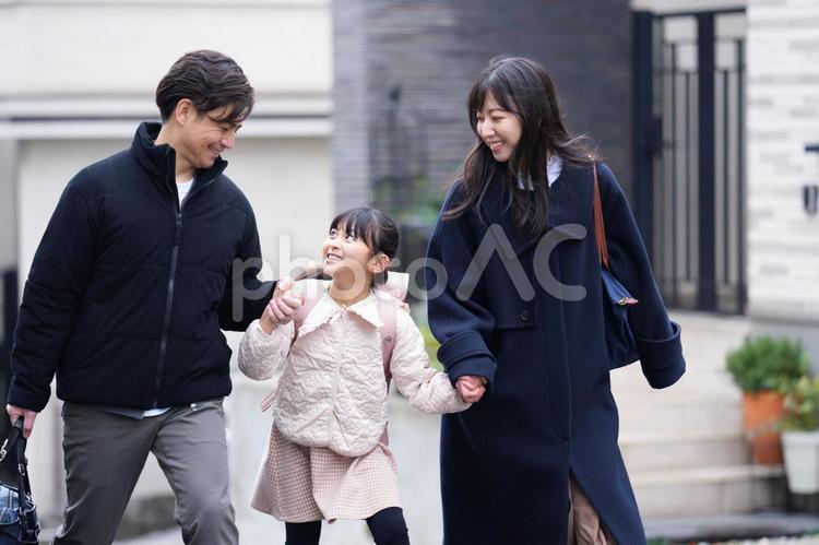 手を繋いで見つめる見つめる家族 女の子,女性,男性の写真素材