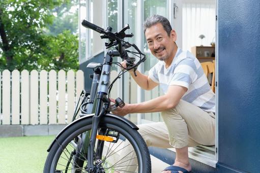 電動自転車をメンテナンスをするミドル男性 電動自転車,男性,自転車の写真素材