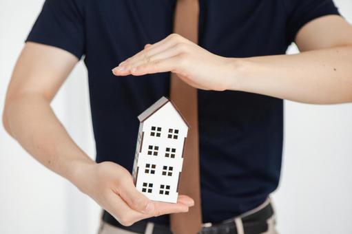 模型の家を守ろうとする男性の手元 保険業,事務職,接客業の写真素材