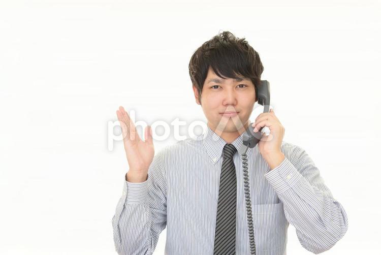 受話器を持って案内するビジネスマン 男性,ビジネス,ビジネスマンの写真素材