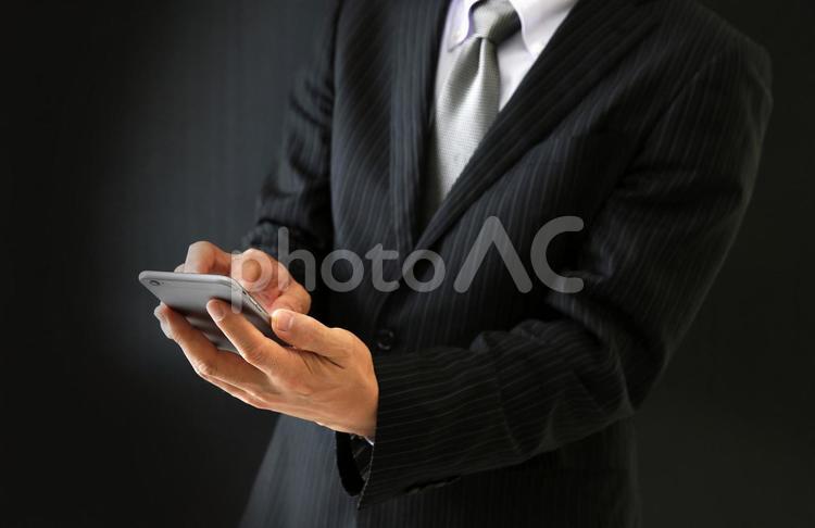 スマホを操作するビジネスマン 詐欺,振り込め詐欺,借金の写真素材