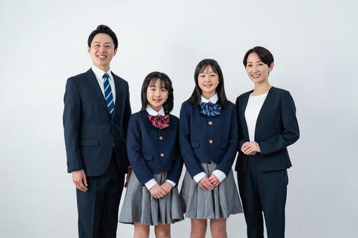 スーツを着た男女と制服を着た女の子二人 入学式,父母,母親の写真素材