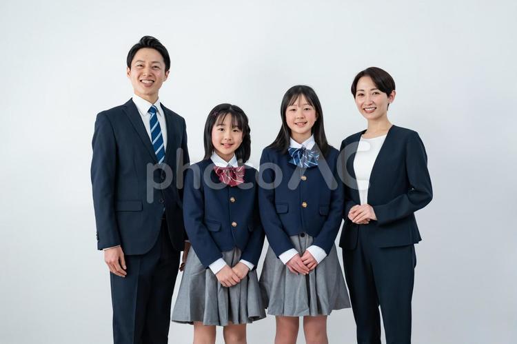スーツを着た男女と制服を着た女の子二人 入学式,父母,母親の写真素材