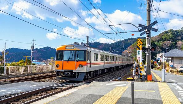 駅の踏切を走る電車 駅の踏切を走る電車の写真