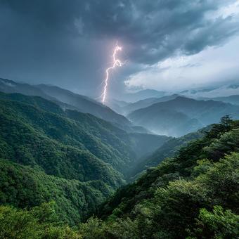 深緑の山々に落ちる稲妻の瞬間 深緑の山々に落ちる稲妻の瞬間の写真