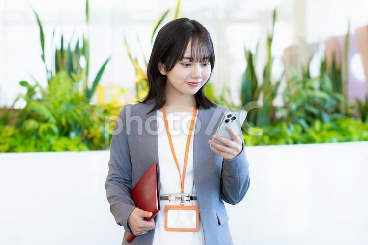 スマホを操作するビジネスウーマン ビジネスウーマン,スマホ,笑顔の写真素材