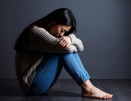 床に座り込み落ち込む女性 床に座り込み落ち込む女性の写真