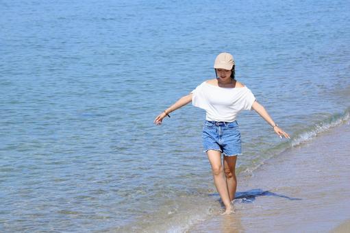 波打ち際を歩く女性 波打ち際を歩く女性 女性,波打ち際,海の写真素材