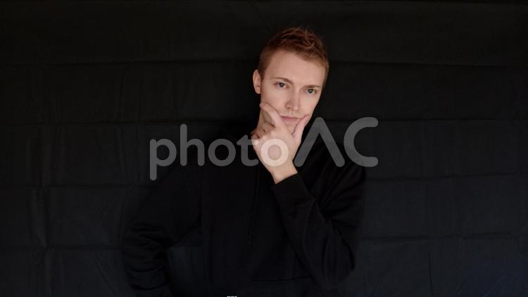 イケメンポーズをしている男　外国人男性　黒バック ポーズ,かお,顔の写真素材