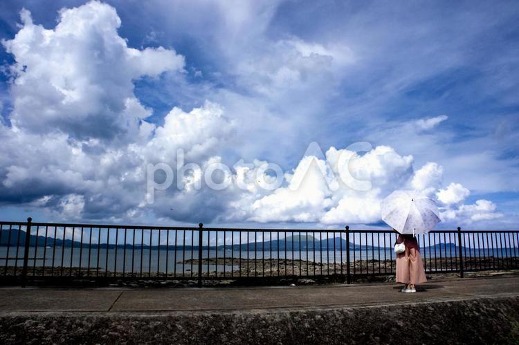 ＜素材＞夏の海沿いの防波堤を散策する女性 女性,青空,大空の写真素材