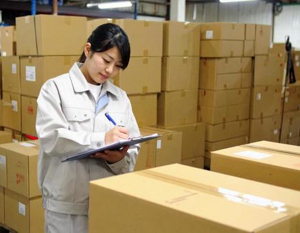 倉庫で在庫をチェックする女性作業員 倉庫で在庫をチェックする女性作業員の写真