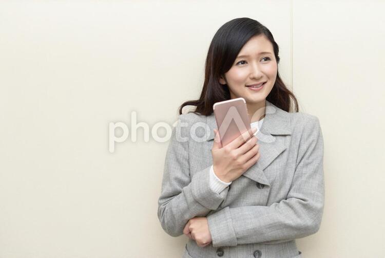 スマートフォンを持つ笑顔の女性 女性,ビジネスウーマン,女の写真素材