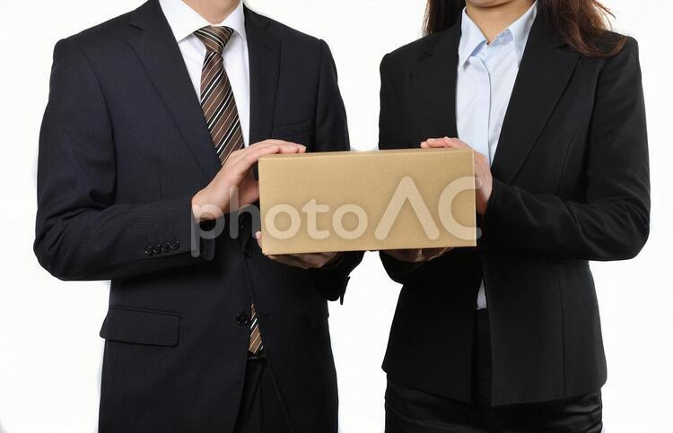 荷物を持っているビジネスマン男女 2人,お届け,カップルの写真素材