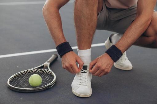 靴ひもを結ぶ男性の手元 テニスシューズ,靴紐,結ぶの写真素材