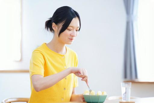 微笑みフォークでリンゴを刺す女性の写真