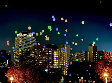 夜空に舞うカラフルなランタンと街の灯り 夜空に舞うカラフルなランタンと街の灯りの写真