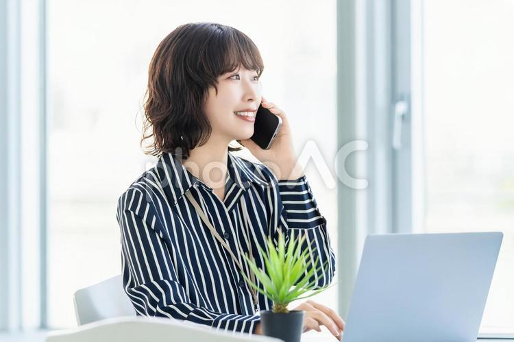 スマホで話す笑顔の女性・ビジネスウーマン 女性,ビジネス,スマホの写真素材