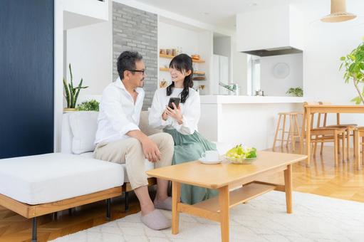 リビングでスマホを見るミドルの夫婦 リビングでスマホを見るミドルの夫婦 夫婦,家族,ミドルの写真素材