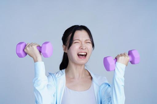 水色の服の女性がピンクのダンベルを持つ 女性,ダンベル,持つの写真素材