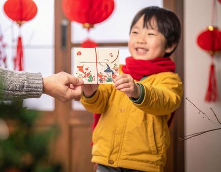正月にポチ袋でお年玉をもらって喜ぶ子供 正月にポチ袋でお年玉をもらって喜ぶ子供の写真