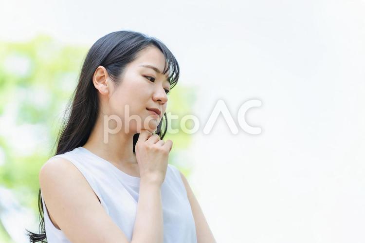 新緑の中で悩む日本人女性（困る） 困る,悩む,女性の写真素材