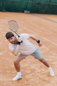 ラケットを伸ばすピンクのシャツの男性 男性,外国人,テニスの写真素材