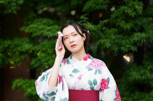 浴衣姿の女性がハンカチで額をぬぐう 女性,浴衣,ハンカチの写真素材