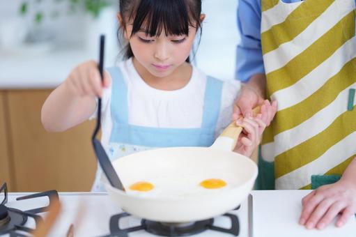 あたたかな料理を作るエプロン姿の女の子 女の子,料理,日本人の写真素材