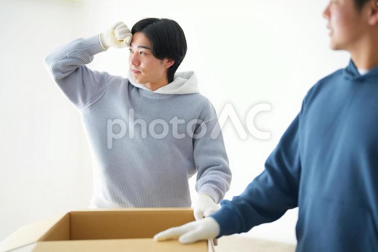 引っ越しの荷造り中の2人の男性 引っ越し,一人暮らし,男性の写真素材