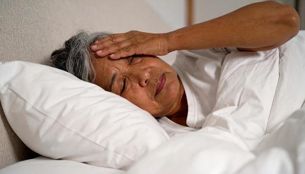 夜、眠れずに悩むシニア女性の横顔 夜、眠れずに悩むシニア女性の横顔の写真