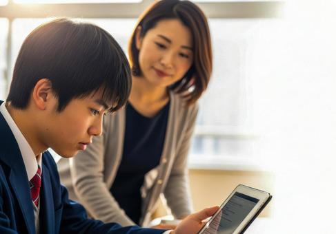 タブレットを使い教師と学習する男子学生 タブレットを使い教師と学習する男子学生の写真
