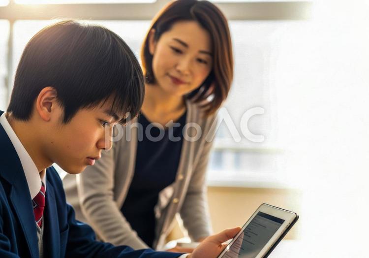 タブレットを使い教師と学習する男子学生 教師,先生,生徒の写真素材