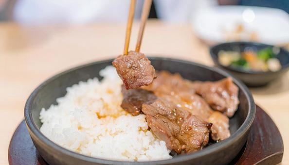 焼き肉を白ご飯に着けて食べる 焼き肉を白ご飯に着けて食べるの写真