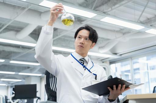 実験をする白衣の若い男性研究者 実験をする白衣の若い男性研究者 研究,実験,サイエンスの写真素材