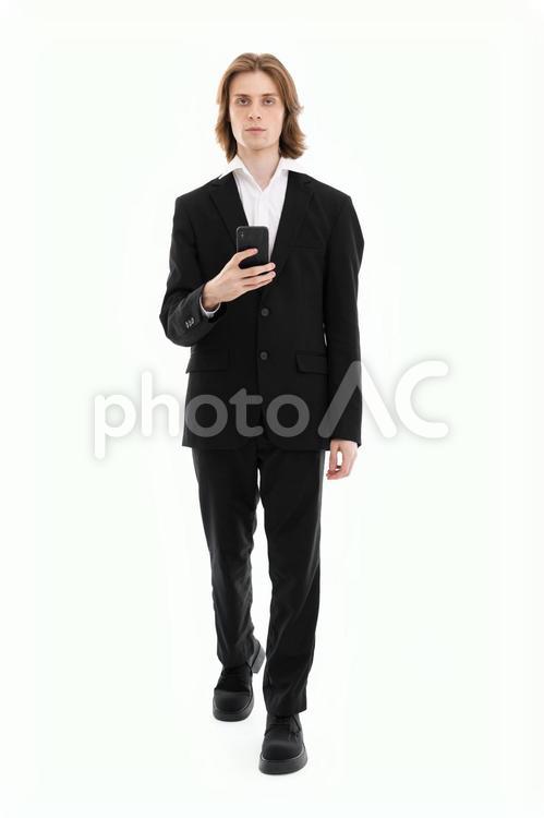 カメラ目線で歩きスマホの男性 男性,スマートフォン,持つの写真素材