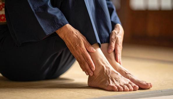 正座のあと、痺れた足をさする男性 正座のあと、痺れた足をさする男性の写真