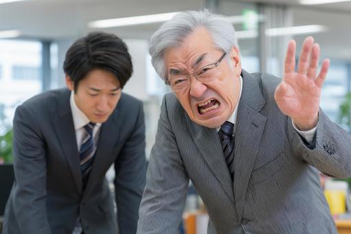 怒る男性と謝るビジネスマン。パワハラの写真