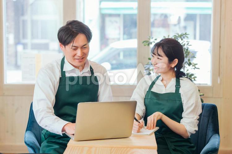 レストラン・カフェ・飲食店を経営する男女 ネットショップ,オンラインショップ,パソコンの写真素材