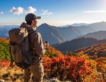 秋晴れの山頂でコーヒーを飲む男性登山者 秋晴れの山頂でコーヒーを飲む男性登山者の写真