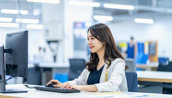 工場の三次元測定機を使う作業服の女性 工場の三次元測定機を使う作業服の女性の写真