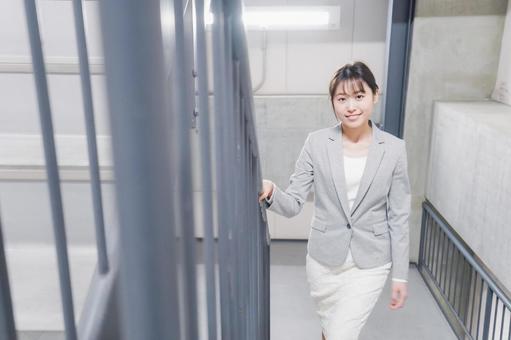 オフィス内を歩く若いビジネスウーマン オフィス内を歩く若いビジネスウーマンの写真