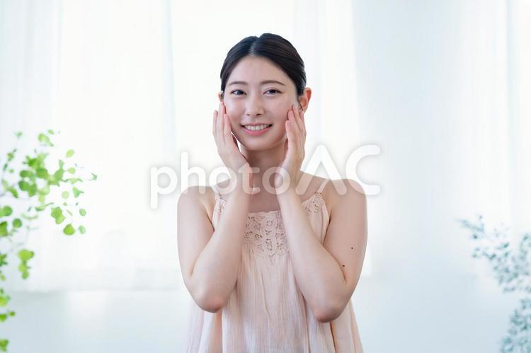 頬に手を当てているスキンケアイメージ 女性,美容,スキンケアの写真素材