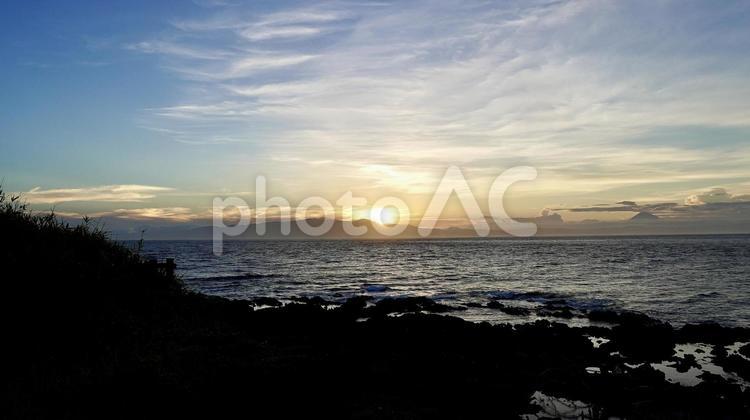 伊豆大島の海岸から見える夕日 海,海辺,波の写真素材