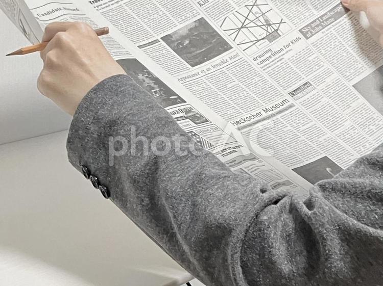 印をつけながら英字新聞を読むイメージ 新聞,英字新聞,英語新聞の写真素材