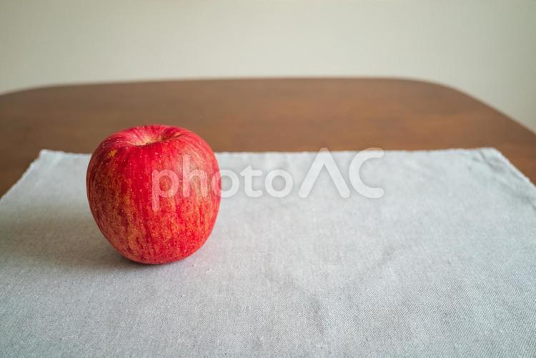 机の上に熟した赤いリンゴが一つ 果物,フルーツ,食の写真素材