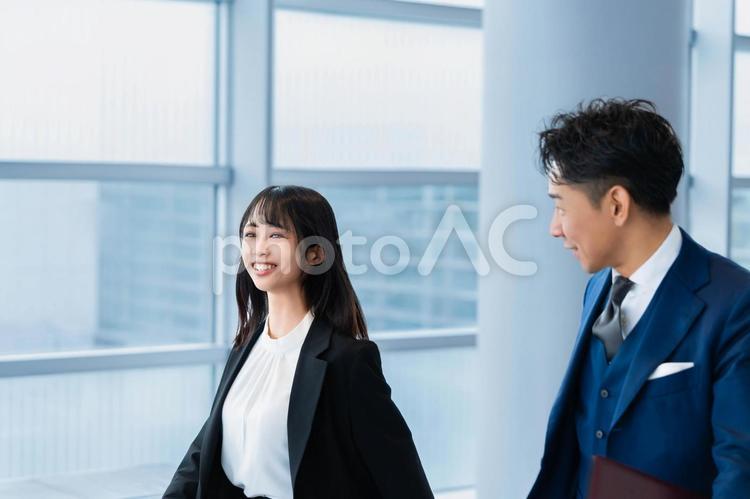 同僚と笑顔で歩く若いビジネスウーマン ビジネスウーマン,ビジネスマン,女性の写真素材