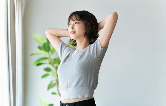 日差しが注ぐ明るい窓際に立つ女性 日差しが注ぐ明るい窓際に立つ女性 女性,爽やか,清々しいの写真素材
