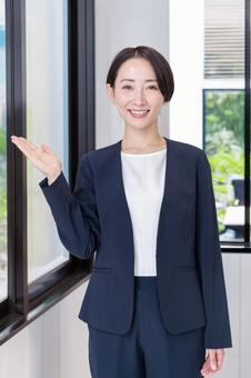 笑顔で案内するスーツ姿の女性 ビジネス,女性,案内の写真素材