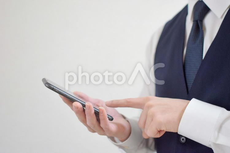 スマホを操作するビジネスマン② ビジネスマン,会社員,男性の写真素材